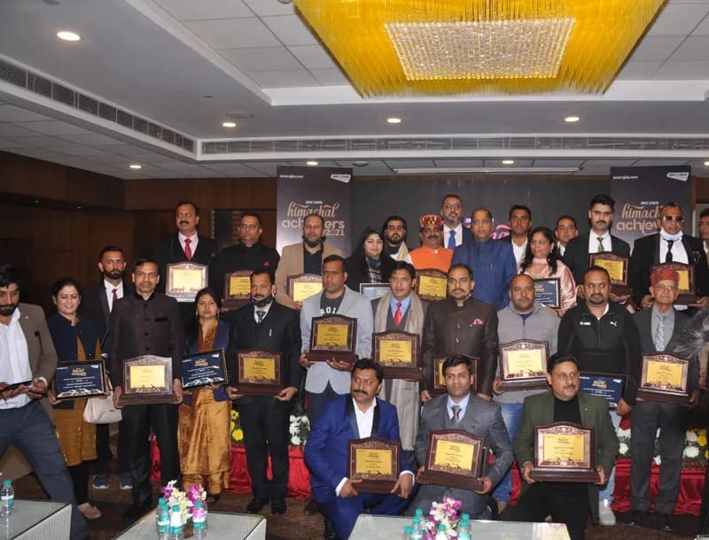 Group photo of awardees holding plaques on stage at the Himachal Achievers 2021 event (Amar Ujala backdrop)