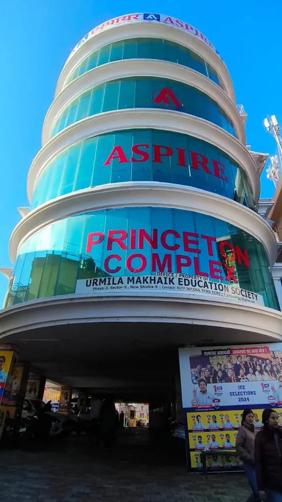 Aspire IIT & Medical building in Shimla: a curved glass-fronted tower (Princeton Complex, Sector 5, New Shimla) with Aspire signage, seen from street level
