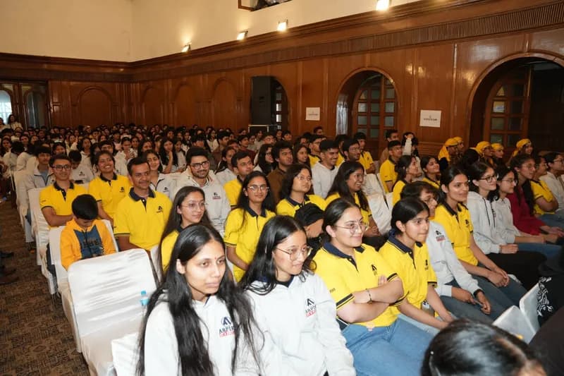 Aspire students in yellow and grey uniforms seated in a large hall during an institute event