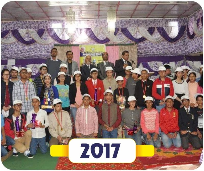 Brain of Himachal 2017: large group of prize winners in caps with trophies and guests in a decorated hall (year label printed on the image)