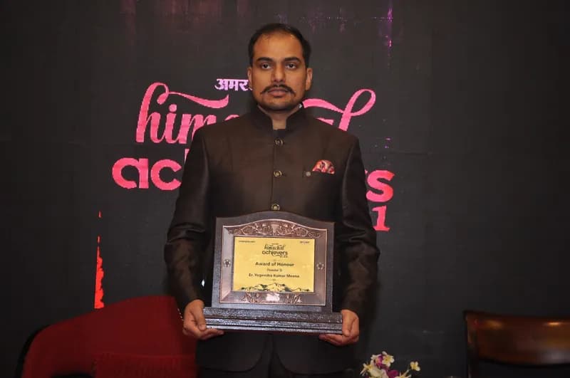 Aspire director holding an award plaque at the Himachal Achievers 2021 event (Amar Ujala backdrop)
